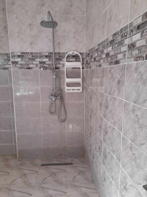 Een douche, handdoeken, zeep, toiletpapier