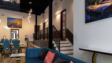 Un intérieur moderne avec un canapé bleu, un escalier en bois et un coin repas doté de chaises bleues.