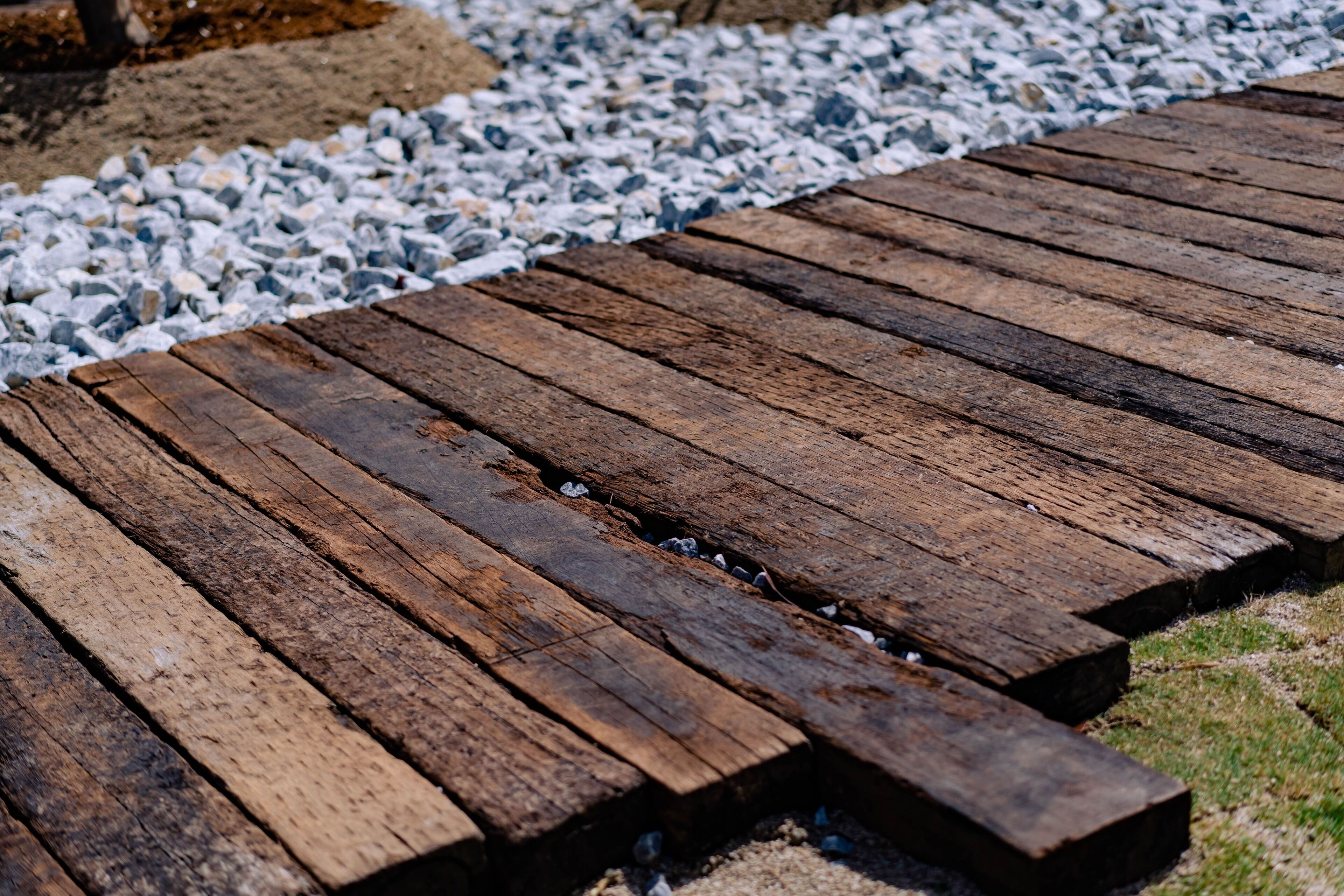 A wooden deck with a gravel path beside it.