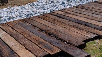 A wooden deck with a gravel path beside it.