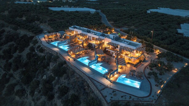 A modern resort with multiple swimming pools, outdoor seating areas, and a well-lit interior. - 2 Bedroom Villa in Mediterranean View Villas in Makri gialos (Makry Gialos)