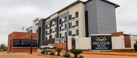 A modern hotel building with a prominent sign for the Premier Hotel Thohoyandou.