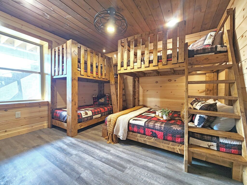 L’intérieur d’une cabine est aménagé avec deux lits superposés, une échelle en bois et une fenêtre qui laisse entrer la lumière naturelle.