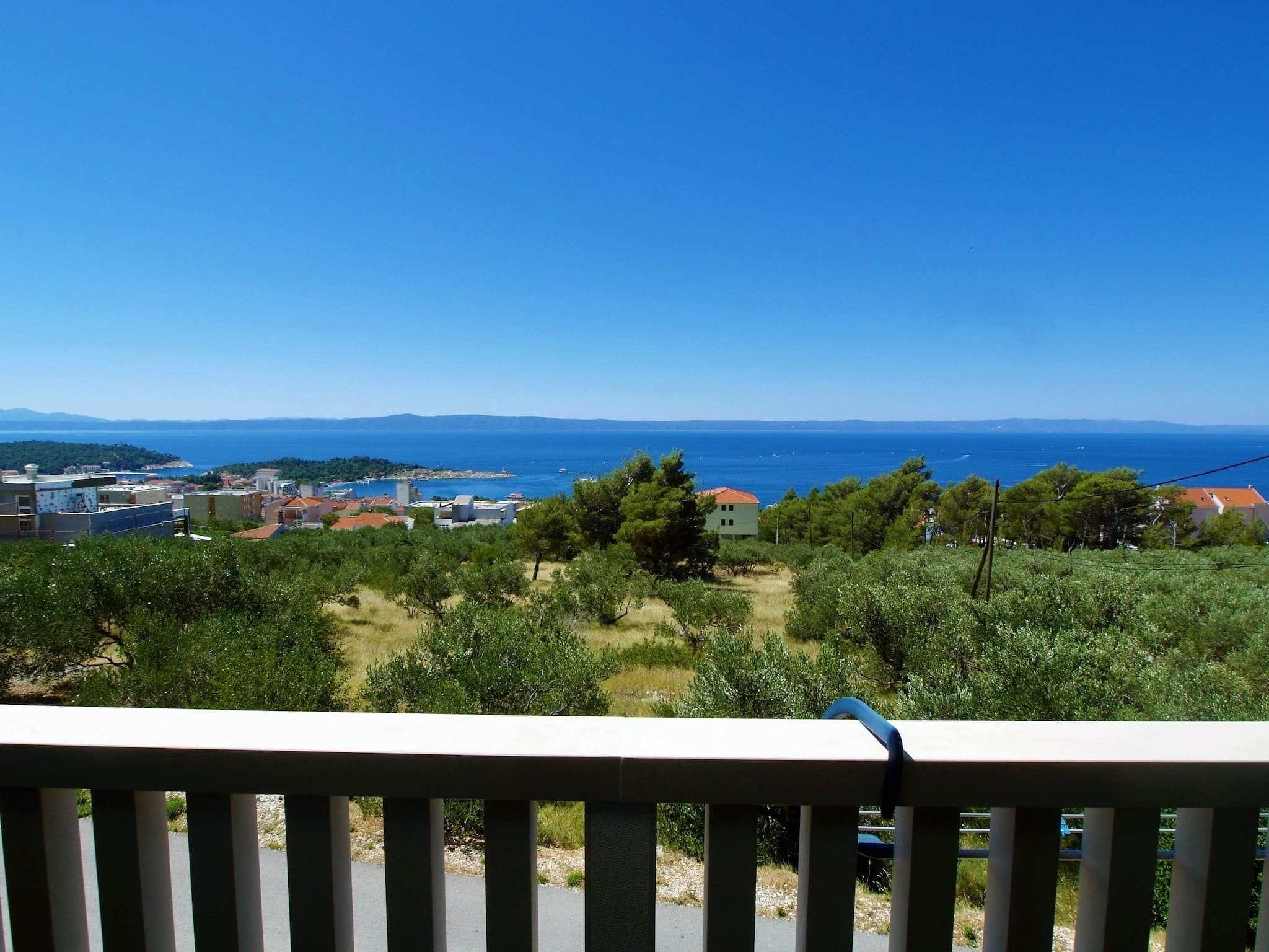 Blick auf die Küste mit Gebäuden, Bäumen und blauem Himmel.
