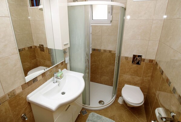 A bathroom with a shower, toilet, and sink. - Adria View, Apartment Ina with pool (Makarska)