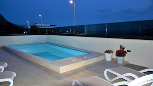 A rooftop swimming pool with lounge chairs and potted plants. - Adria View, Apartment Dado, with pool (Makarska)