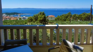 A balcony with a view of the sea and distant buildings. - Adria View, Apartment Dado, with pool (Makarska)