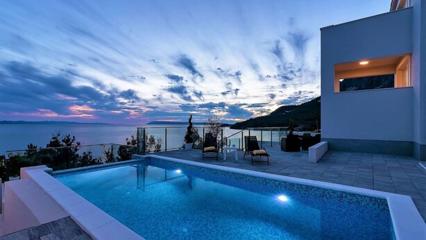 A modern outdoor pool area with a view of the sea and mountains. - Villa Legero with pool (Drašnice)