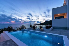 A modern outdoor pool area with a view of the sea and mountains. - Villa Legero with pool (Drašnice)
