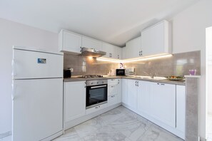 Een koelkast, een oven, een kookplaat, een vaatwasser
