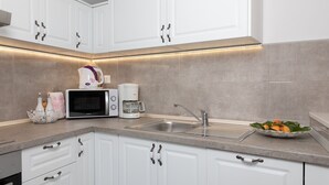A modern kitchen with white cabinets, a built-in microwave, a coffee maker, and a sink. - Villa Silencio with pool (Tucepi)