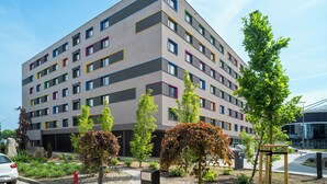 A multi-story building with a modern architectural design, featuring a mix of rectangular and square windows. - NextDoor Apartments (Kraków)