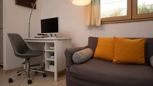 Une pièce comprenant un bureau, une chaise et un canapé.