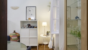 Uma casa de banho moderna com cabine de chuveiro em vidro, toucador branco com espelho e armário de vidro para artigos de higiene pessoal.