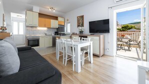 A modern apartment with a kitchen, dining area, and a balcony with a view. - Green Hills Apartment (Dubrovnik)