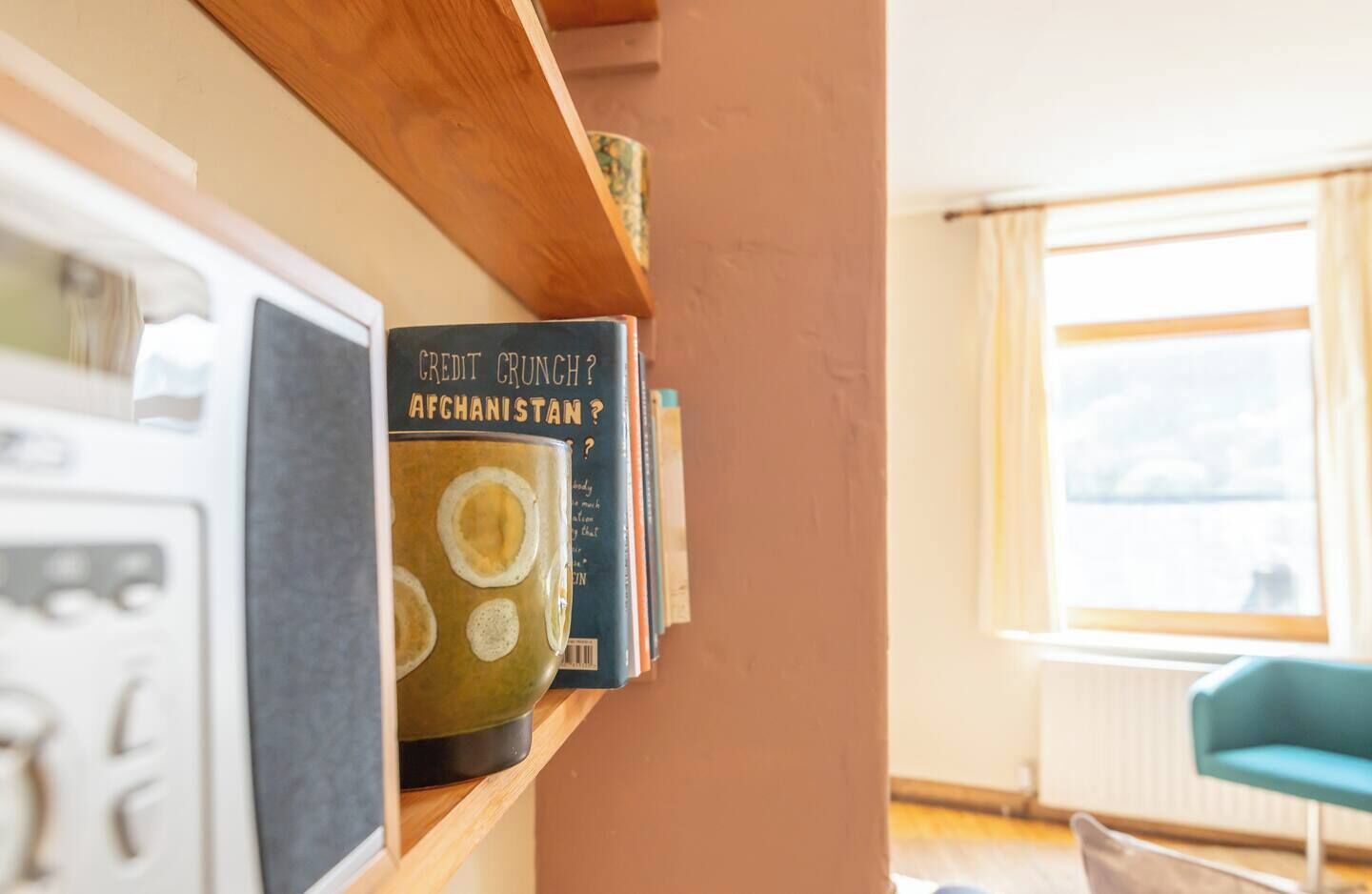 Een boekenplank met boeken en een magnetron.