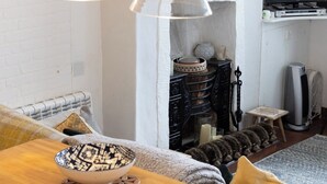 A cozy living room with a wooden coffee table, a fireplace, and a television. - Water View Cottage, Water View Cottage (Conwy)