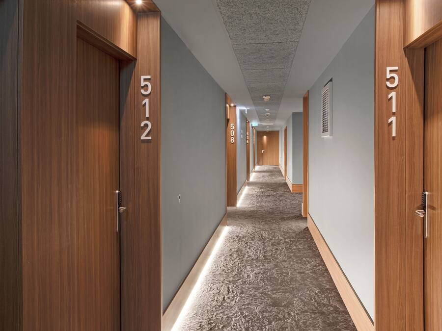 A hotel hallway with wooden doors, numbered 512 and 511, and a patterned carpet.