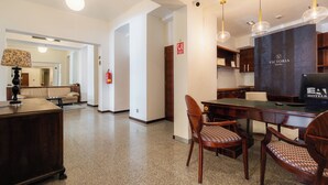 A hotel room with a dining area, a sofa, a lamp, and a fire extinguisher. - EA Hotel Victoria (Prague)
