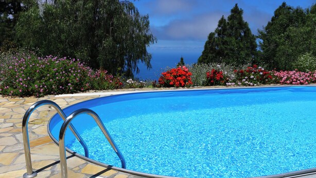 A swimming pool with a stone deck and metal ladder. - Villa Finca Tijarafe with heated pool (Tijarafe)