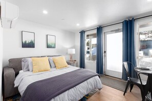 Une chambre d’hôtel avec un lit, un canapé, une table avec une chaise et une fenêtre avec des rideaux.