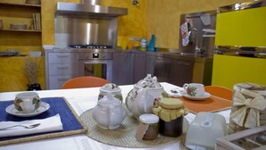 A dining area with a table set for tea, including teapots, cups, and a sugar bowl. - Casa il Girasole con piscina  (Macerata)