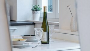 Una mesa de comedor con una botella de vino, copas y fuentes.