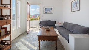 Ein modernes Wohnzimmer mit einem grauen Sofa, einem Holztisch und einem Bücherregal.