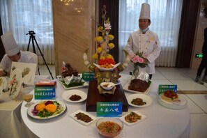 En buffet med forskellige retter og et blomsterarrangement.