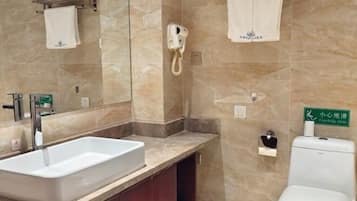 A bathroom with a white sink, a mirror, a towel rack, a toilet, and a hand dryer.