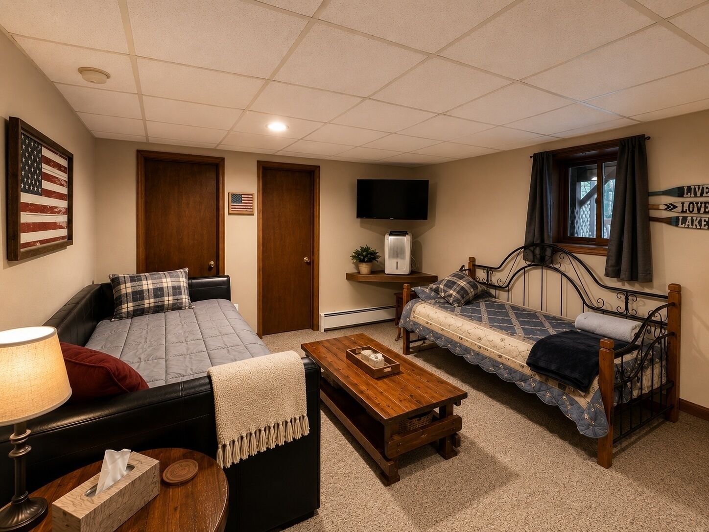 A room with two beds, a TV, a lamp, and a sign indicating directions to nearby attractions.
