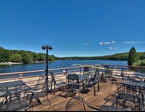 A deck with outdoor seating overlooking a lake. - Welcome to the Brentwood Chalet in The Hideout (Lake Ariel)
