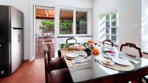 A dining area with a table set for breakfast, including fruits, pastries, and beverages. - Luxury Villa with Private SPA, Heated Jacuzzi, Pool and Sea-View Terrace (Sorrento)