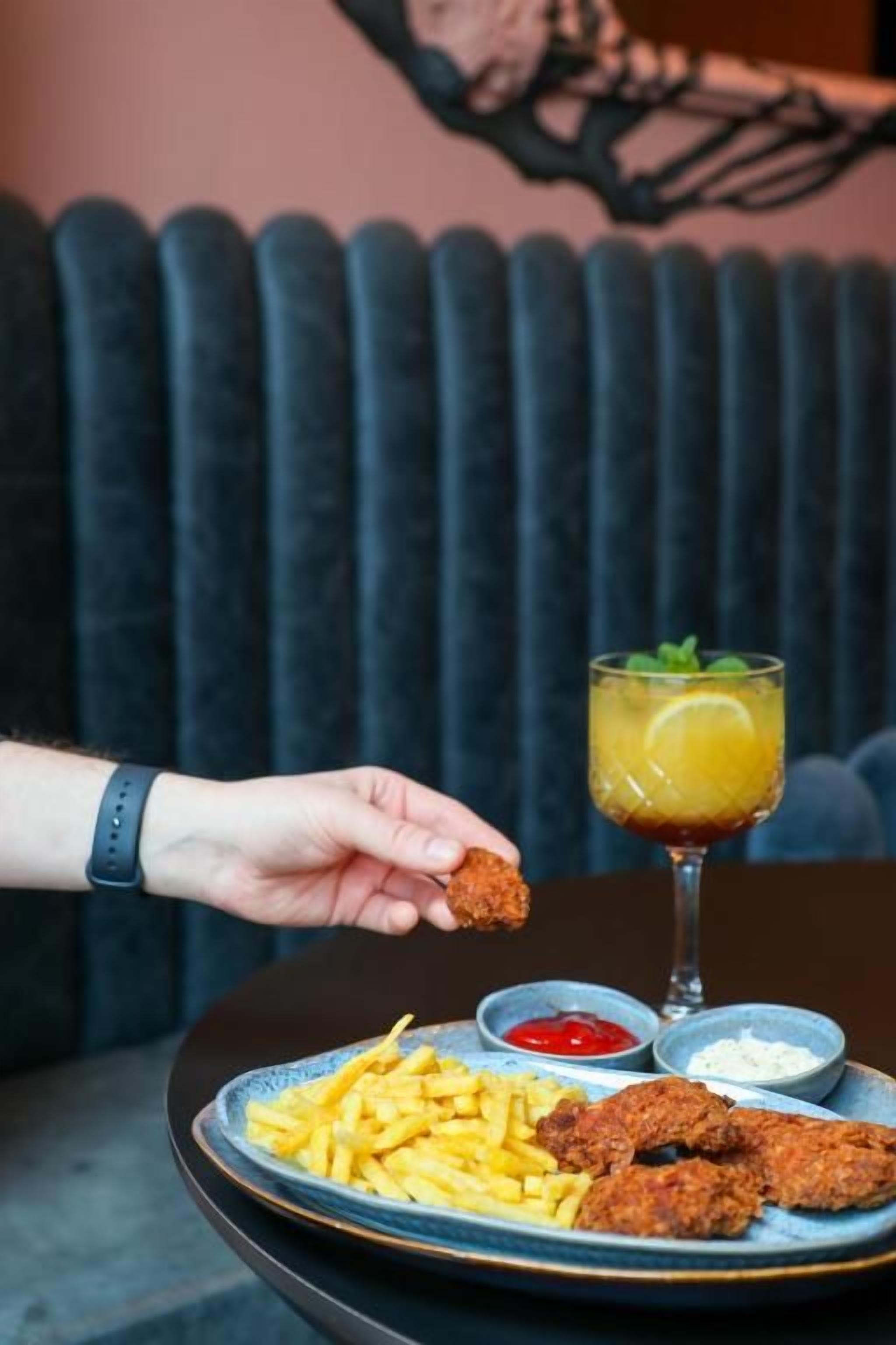 A plate with fried food and a drink on a table.