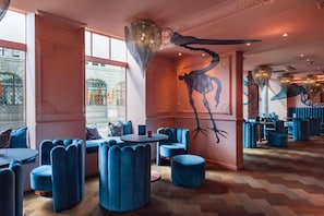 A modern interior with seating areas, a large wall mural, and a patterned floor. - VISIONAPARTMENTS Lugano (Lugano)