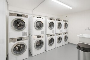 A laundry facility with multiple washing machines arranged in a row.