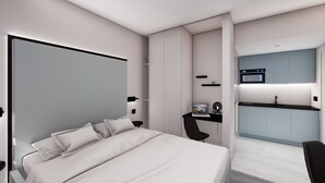 A modern hotel room with a bed, a desk, and a kitchenette.