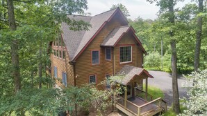 A large wooden house with a porch, surrounded by trees. - Rustic-Meets-Modern Cabin Near Deep Creek (McHenry)