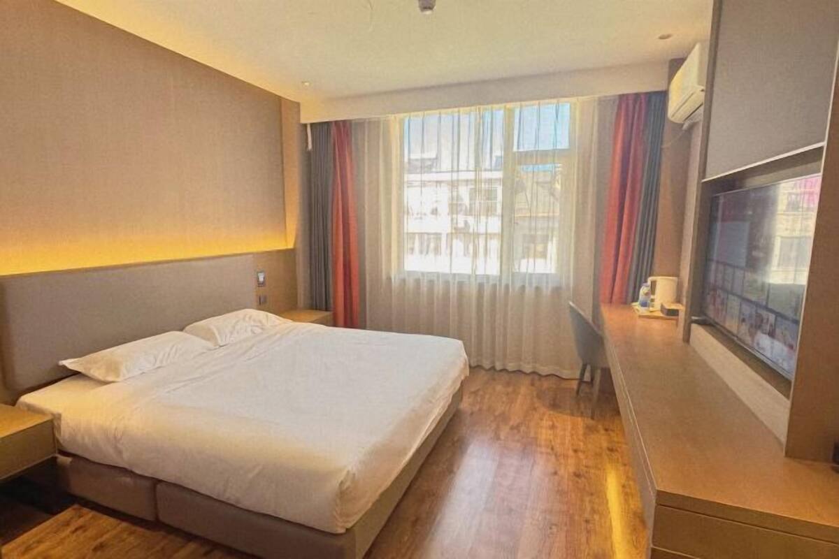 Una habitación de hotel con una cama, un escritorio y un televisor.