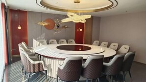 A modern conference room with a round table, comfortable chairs, and a unique ceiling light fixture. - Zhuoya Smart Hotel (Tonghua)