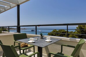 Enjoy a serene view of the water from this outdoor space, complete with a table and chairs.