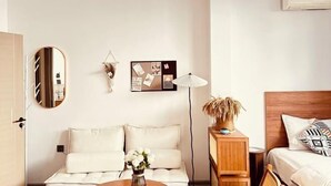 Une chambre à coucher moderne avec une tête de lit en bois, une table de chevet avec une lampe et un cadre photo fixé au mur.