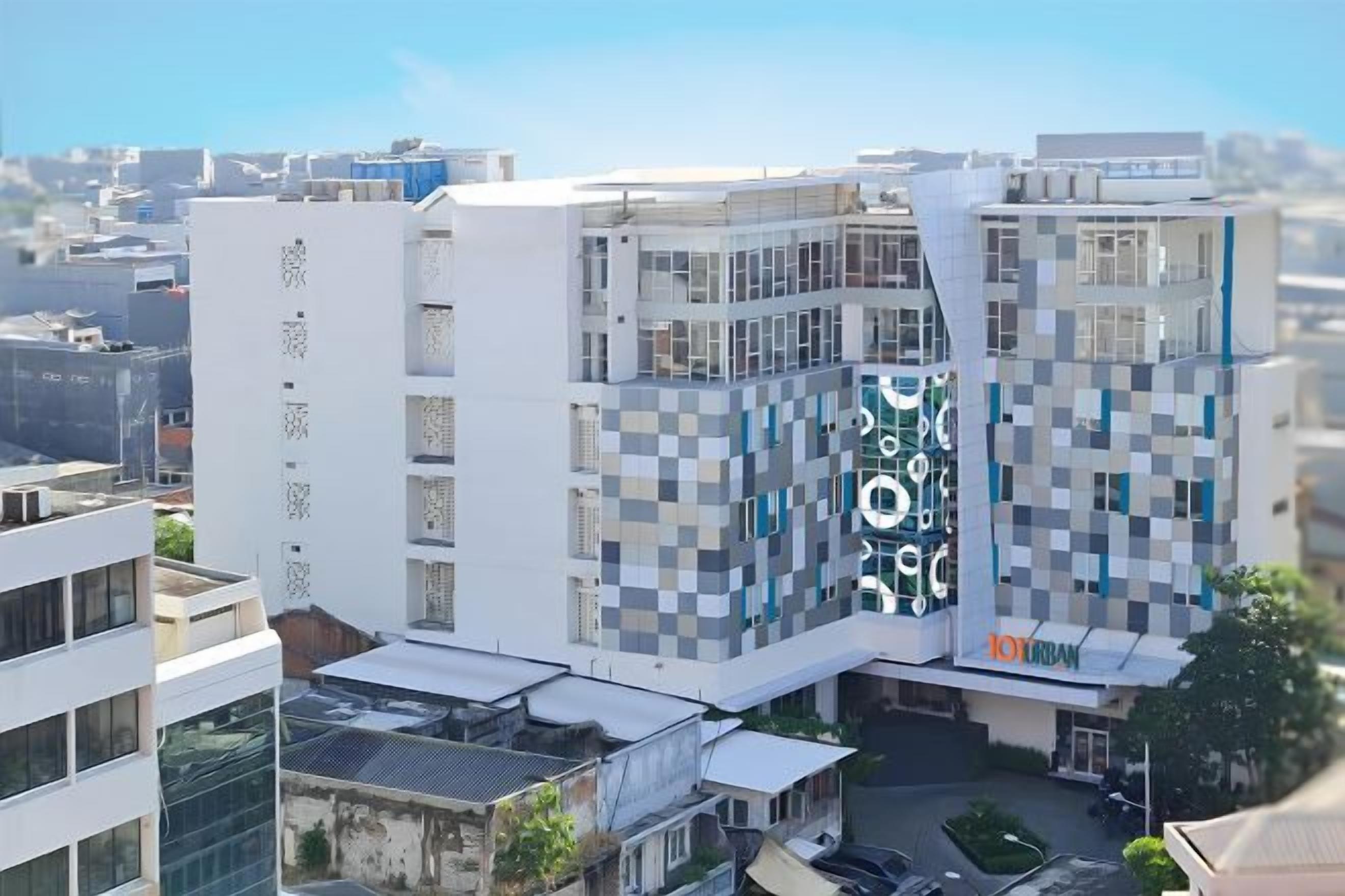 A modern multi-story building with a distinctive checkered facade, a prominent logo, and a visible entrance.