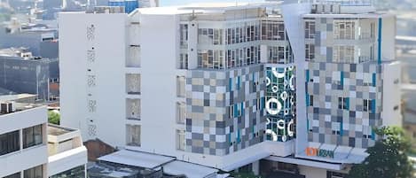A modern building with a checkered facade, a visible 'TOURBAN' sign, and a clear view of the surrounding urban area.