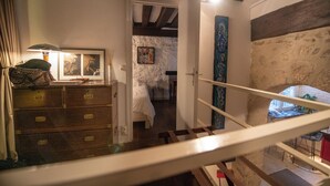A staircase leading to a bedroom with a bed, a dresser, and a painting on the wall. - Your stay in the heart of Paris in a large duplex apartment. Saint Germain (Paris)