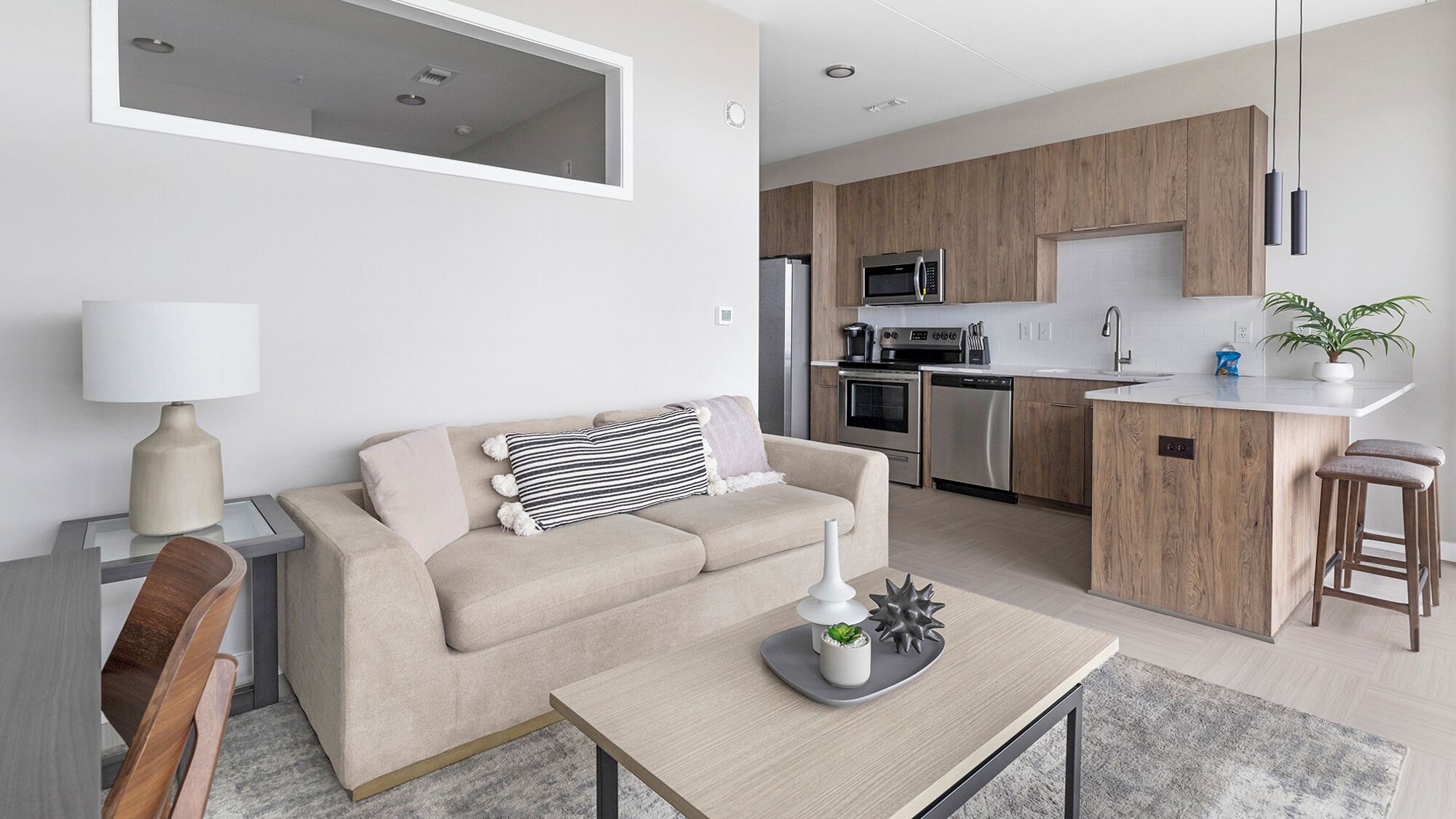 Ein modernes Apartment mit Wohnzimmer, Küche und Essbereich.