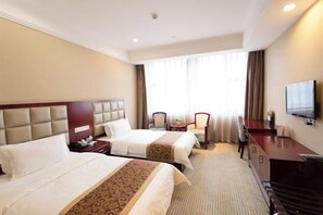 A hotel room with two beds, a desk, a chair, a television, and a window with curtains. - Guomao Hotel (Yichang)