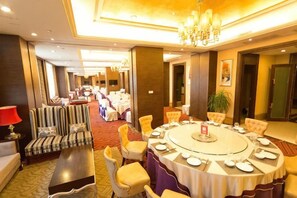 A hotel conference room with a round table, chairs, and a sofa. - Guomao Hotel (Yichang)