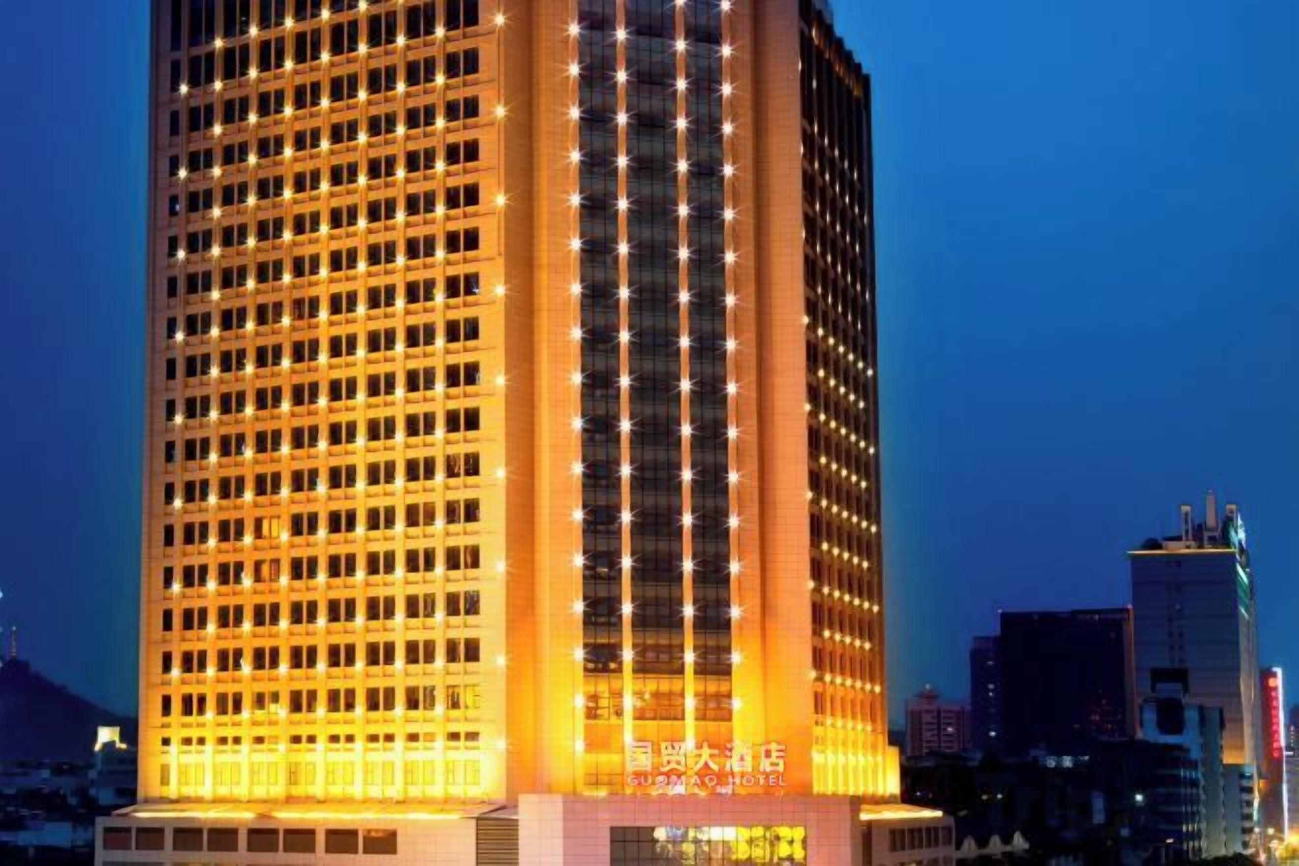 A high-rise building with a grid of windows and illuminated signage.
