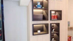 A wall with four black shelves, each containing different items. - HanTing Hotel (Jilin Street Railway Station) (Jilin City)